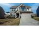 Two-story home with stone accents, covered front porch, and attached two-car garage at 154 Rooster Tail Ln, Troutman, NC 28166