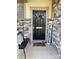 Charming front porch with decorative stone accents and a welcoming black front door at 154 Rooster Tail Ln, Troutman, NC 28166