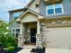 Charming home featuring a stone facade, covered porch, and well-maintained landscaping at 154 Rooster Tail Ln, Troutman, NC 28166