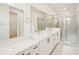 Modern bathroom featuring double sinks, quartz countertop, and glass shower at 163 Windy Dell Dr, Tega Cay, SC 29708