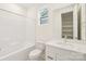 Modern bathroom features shower-tub combo, white cabinets, and a large framed mirror at 163 Windy Dell Dr, Tega Cay, SC 29708