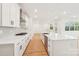 Open kitchen with a spacious island, white cabinetry, stainless steel accents, and hardwood flooring at 163 Windy Dell Dr, Tega Cay, SC 29708