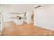 Bright and airy kitchen with white cabinetry, a center island, and hardwood floors open to the living area at 163 Windy Dell Dr, Tega Cay, SC 29708