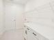 Laundry room with tile floors, modern white cabinets, and a shelf for storage at 163 Windy Dell Dr, Tega Cay, SC 29708