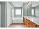 Well-lit bathroom with a tub, a window, wooden cabinets, and tiled floors at 16606 Spruell St, Huntersville, NC 28078