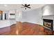 Open-concept living room boasts hardwood floors, fireplace, and ceiling fan at 16606 Spruell St, Huntersville, NC 28078