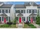 Townhouses with a charming front entrance, vibrant red doors, and manicured landscaping at 253 W G St, Kannapolis, NC 28081