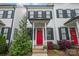 Townhouse front exterior with black shutters, landscaping, and vibrant red door at 253 W G St, Kannapolis, NC 28081