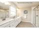 Elegant bathroom with dual sinks, white cabinets, tiled floors, and a separate glass-enclosed shower at 3010 Bramble Hedge Rd # 3271, Indian Trail, NC 28079