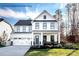 Charming two-story home showcasing a well-manicured lawn, two-car garage, and a welcoming front porch with rocking chairs at 3010 Bramble Hedge Rd # 3271, Indian Trail, NC 28079