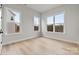 A sunlit bedroom has hardwood floors and large windows with scenic views at 3050 Tramore Dr, Harrisburg, NC 28075