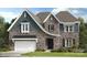 Charming two-story home with stone and siding facade, well-maintained landscaping, and an attached two-car garage at 3050 Tramore Dr, Harrisburg, NC 28075