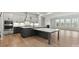 A modern kitchen and living room with gray cabinets, quartz countertops, and hardwood floors at 3050 Tramore Dr, Harrisburg, NC 28075