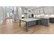 A modern kitchen and foyer with gray cabinets, quartz countertops, and hardwood floors at 3050 Tramore Dr, Harrisburg, NC 28075