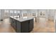 A modern kitchen island with gray cabinets, quartz countertops, and hardwood floors at 3050 Tramore Dr, Harrisburg, NC 28075