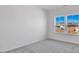 Minimalist bedroom with a large window showcasing neighborhood views and soft carpeting at 3057 Tramore Dr, Harrisburg, NC 28075