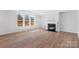 Bright living room featuring a fireplace, large windows, and wood-look flooring at 3057 Tramore Dr, Harrisburg, NC 28075