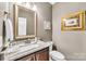Charming half bathroom with a marble countertop vanity, toilet, and a decorative mirror at 315 Muirfield Way, Salisbury, NC 28144