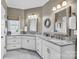 Elegant bathroom featuring dual sinks with granite countertops, white cabinetry and stylish mirrors at 315 Muirfield Way, Salisbury, NC 28144