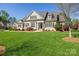 Charming home featuring a manicured lawn, neutral siding, dark shutters, and a welcoming front porch at 315 Muirfield Way, Salisbury, NC 28144