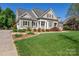 Well-maintained home with lush landscaping, neutral siding, dark shutters, and a pristine lawn at 315 Muirfield Way, Salisbury, NC 28144