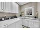 Functional laundry room with white cabinets, countertop space, and a sink at 315 Muirfield Way, Salisbury, NC 28144
