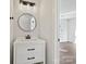 Modern powder room with a sleek vanity, round mirror, modern lighting fixtures, and a glimpse of an open room at 3201 Decapolis Dr, Charlotte, NC 28215