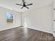 Bright bedroom with large window, ceiling fan, and hardwood floors; ready for you to turn it into a cozy space at 3201 Decapolis Dr, Charlotte, NC 28215