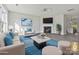 This staged living room showcases a cozy fireplace, stylish decor, a modern light fixture, and beautiful wood floors at 3201 Decapolis Dr, Charlotte, NC 28215