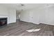 Open-concept living room featuring wood floors, modern light fixture, and fireplace, perfect for entertaining guests and relaxing at 3201 Decapolis Dr, Charlotte, NC 28215