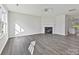 A modern living room with a fireplace, sleek gray wood flooring, lots of natural light, and a contemporary light fixture at 3201 Decapolis Dr, Charlotte, NC 28215