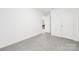 Bright bedroom featuring neutral carpet, a door, and base trim at 32586 Millingport Rd # 7147, New London, NC 28127