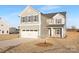 Two-story home featuring a two-car garage, gray siding, and a stone accent base in a spacious yard at 32586 Millingport Rd # 7147, New London, NC 28127