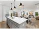 Open-concept kitchen featuring an island with a sink, gray cabinets, and pendant lighting with a dining area at 32586 Millingport Rd # 7147, New London, NC 28127