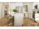Bright, modern kitchen with an island, white cabinetry, stainless steel appliances, and hardwood floors at 3886 Horsham St, Indian Land, SC 29707