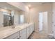 Bathroom featuring double sinks, white cabinets, quartz countertops, a large mirror, and tiled shower at 4171 Skyboat Cir, Fort Mill, SC 29715