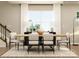 Modern dining room with a wooden table, comfortable seating, and a view through a bright window at 4171 Skyboat Cir, Fort Mill, SC 29715