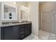 Spacious bathroom with dual sinks set in granite countertop, and a convenient walk-in shower at 5386 Josephine Sw Ln, Concord, NC 28027