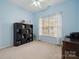 Serene bedroom features blue walls, a window, and a storage shelf for organization at 5386 Josephine Sw Ln, Concord, NC 28027