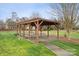 Outdoor picnic area with a wooden pergola, picnic tables, and a grill at 5386 Josephine Sw Ln, Concord, NC 28027