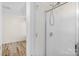 Bathroom featuring a corner glass shower stall, light-colored walls and wood floors at 6821 Parkers Crossing Dr, Charlotte, NC 28215