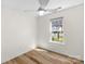 Bedroom featuring hardwood floors, white walls, ceiling fan, and a bright window at 6821 Parkers Crossing Dr, Charlotte, NC 28215