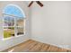 Bedroom featuring hardwood floors, white walls, and a large arched window at 6821 Parkers Crossing Dr, Charlotte, NC 28215
