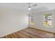 Bedroom with light-colored walls, a ceiling fan, wood floors, and two windows at 6821 Parkers Crossing Dr, Charlotte, NC 28215
