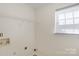 Laundry room features a wire rack and a window with a window shade, with light-colored walls at 6821 Parkers Crossing Dr, Charlotte, NC 28215