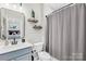 Bright bathroom featuring modern fixtures, a stylish mirror, and a gray shower curtain at 7313 Glenroe Dr, Huntersville, NC 28078