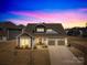 Charming two-story home featuring a landscaped yard, a two-car garage and beautiful lighting at 7313 Glenroe Dr, Huntersville, NC 28078