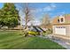 Two yellow jet skis on trailer in yard with garage, trees, and blue sky in background at 938 Pinehaven Dr, New London, NC 28127