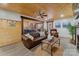 Cozy living room with wood-paneled ceiling, brick fireplace, and open access to the kitchen at 938 Pinehaven Dr, New London, NC 28127