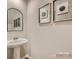 Clean and modern powder room featuring a pedestal sink and decorative accents at 10014 Chatham Run Ln, Charlotte, NC 28262